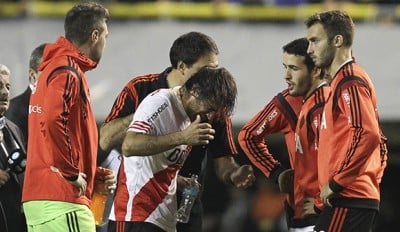 BAS43. BUENOS AIRES (ARGENTINA), 14/05/2015.- Leonardo Ponzio de River Plate se limpia el rostro luego de que lanzaran gas pimienta desde la tribuna hoy, jueves 14 de mayo de 2015, durante un partido por los octavos de final de la Copa Libertadores, en el estado de Boca Juniors en Buenos Aires (Argentina). EFE/David Fernández